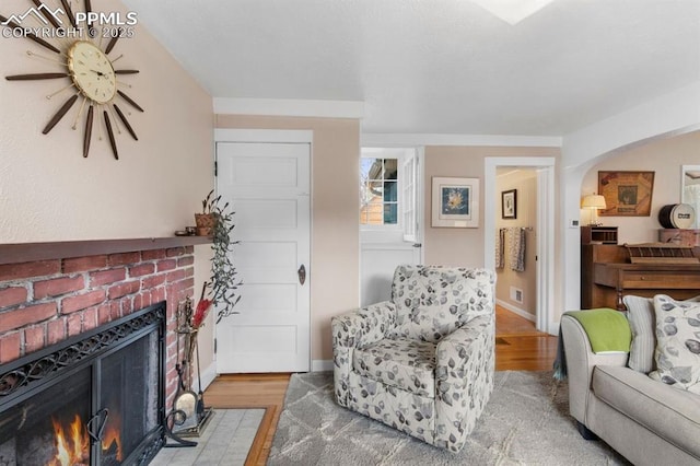 25 Highland St, Colorado Springs, CO 80906 - living area featuring light wood-type flooring, a fireplace, a ceiling fan, and arched walkways
