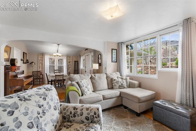 25 Highland St, Colorado Springs, CO 80906 - living room featuring arched walkways, a chandelier, and wood finished floors