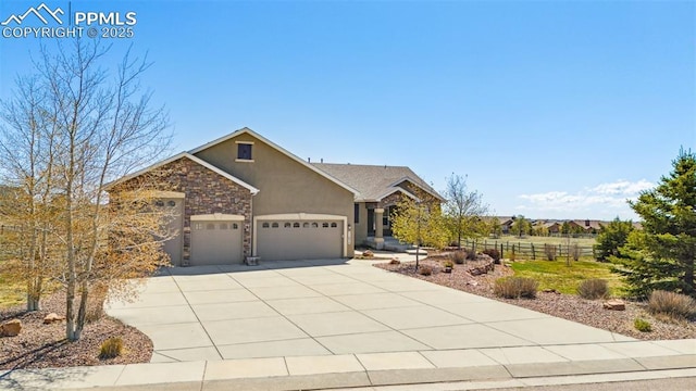 11854 Black Hills Dr, Peyton, CO 80831 - view of front facade featuring fence, an attached garage, stone siding, stucco siding, and concrete driveway