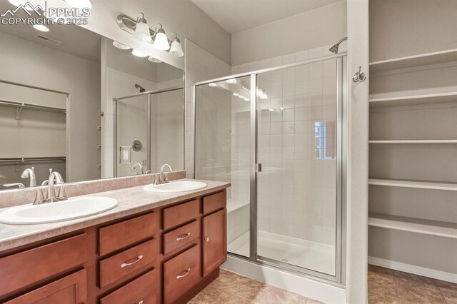 8806 Bella Flora Hts, Colorado Springs, CO 80924 - full bathroom with a stall shower, a walk in closet, double vanity, and tile patterned floors