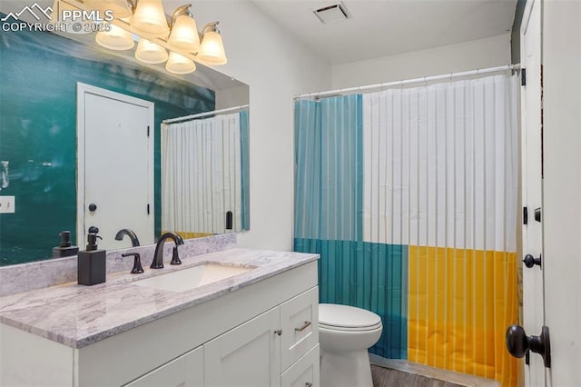 4720 Live Oak Dr, Colorado Springs, CO 80916 - full bathroom featuring vanity, toilet, and wood finished floors