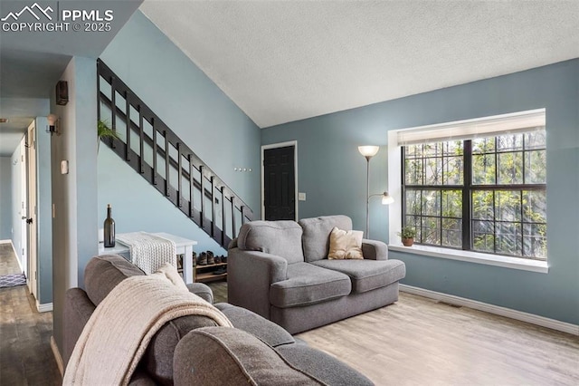 4720 Live Oak Dr, Colorado Springs, CO 80916 - living room with wood finished floors, baseboards, stairs, a textured ceiling, and lofted ceiling