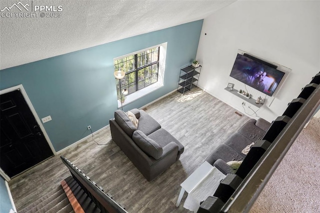 4720 Live Oak Dr, Colorado Springs, CO 80916 - living area with a textured ceiling, wood finished floors, baseboards, and lofted ceiling