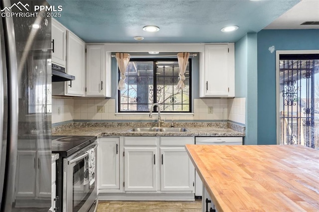 4720 Live Oak Dr, Colorado Springs, CO 80916 - kitchen featuring a sink, appliances with stainless steel finishes, wood counters, under cabinet range hood, and plenty of natural light