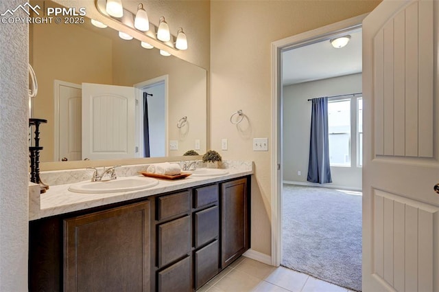 bathroom featuring a sink, tile patterned floors, baseboards, and double vanity