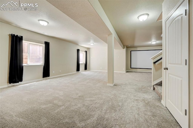 basement featuring carpet floors, baseboards, a textured ceiling, and stairs