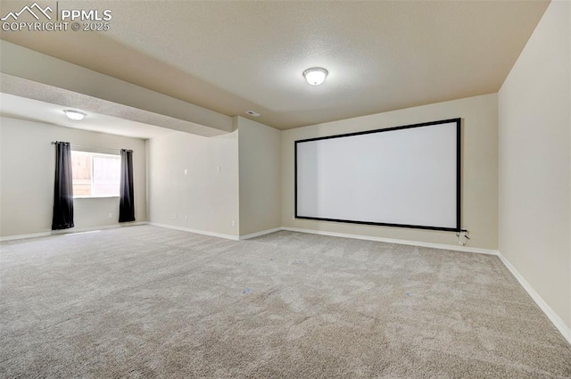 carpeted cinema room featuring baseboards and a textured ceiling