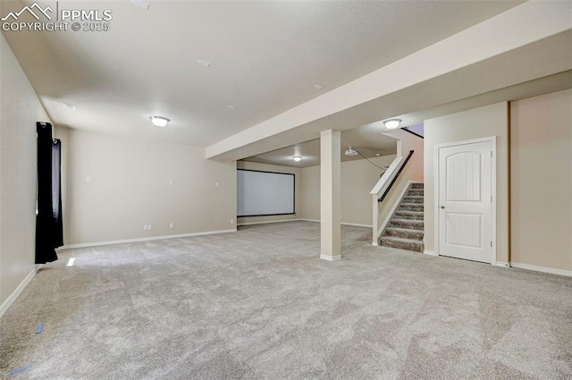 finished basement with stairway, baseboards, and carpet