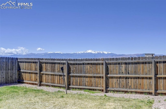 view of yard featuring fence and a mountain view
