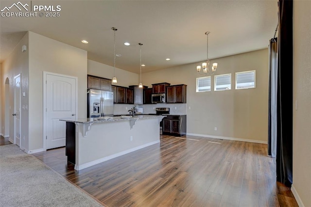 kitchen featuring dark brown cabinetry, appliances with stainless steel finishes, an inviting chandelier, recessed lighting, and wood finished floors