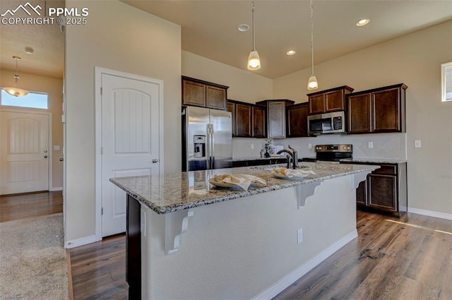 kitchen with dark brown cabinets, appliances with stainless steel finishes, a sink, recessed lighting, and dark wood-style floors