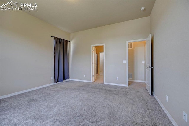 unfurnished bedroom with baseboards, light colored carpet, and visible vents