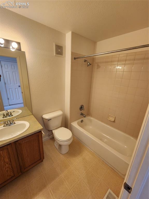 3928 Diamond Ridge Vw, Colorado Springs, CO 80918 - bathroom with toilet, vanity,  shower combination, and a textured ceiling