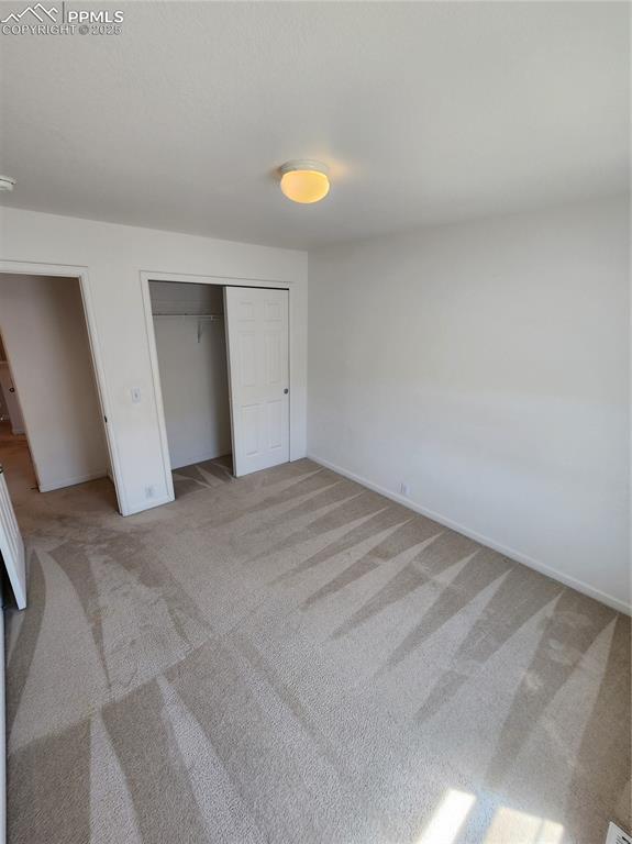 3928 Diamond Ridge Vw, Colorado Springs, CO 80918 - unfurnished bedroom with light carpet, baseboards, and a closet