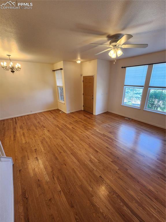 3928 Diamond Ridge Vw, Colorado Springs, CO 80918 - unfurnished room with a chandelier, wood finished floors, baseboards, and a ceiling fan