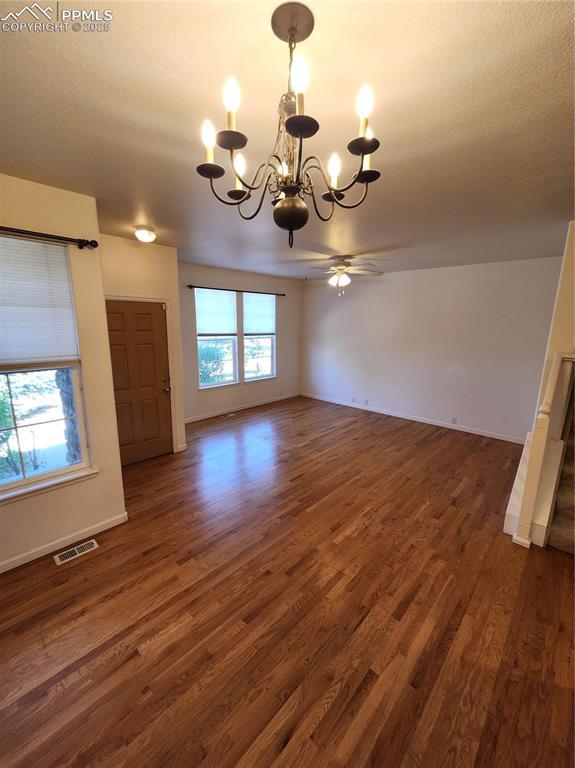 3928 Diamond Ridge Vw, Colorado Springs, CO 80918 - unfurnished dining area featuring a chandelier, dark wood-type flooring, ceiling fan, and baseboards
