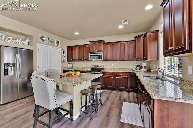 8356 Longleaf Ln, Colorado Springs, CO 80927 - kitchen with a sink, stainless steel appliances, visible vents, dark wood-style flooring, and a kitchen bar