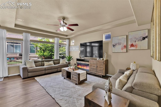 8356 Longleaf Ln, Colorado Springs, CO 80927 - living room featuring a ceiling fan, wood finished floors, a raised ceiling, and a textured ceiling