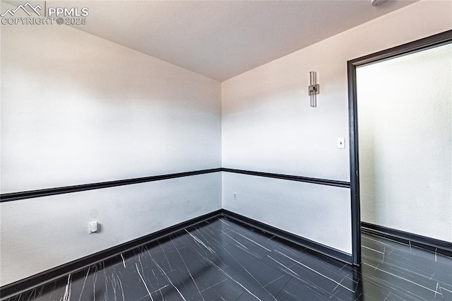 spare room with baseboards