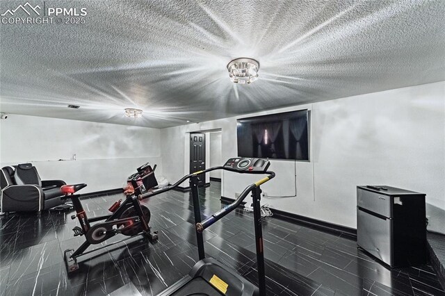 workout room with baseboards and a textured ceiling