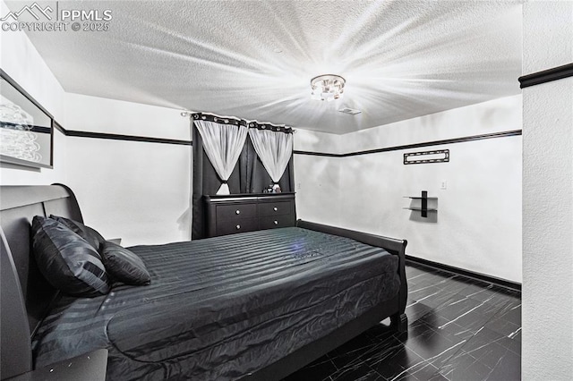 bedroom featuring baseboards, a textured ceiling, and marble finish floor