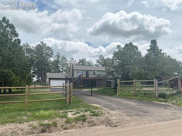 view of front of home with fence, a chimney, a gate, and aphalt driveway