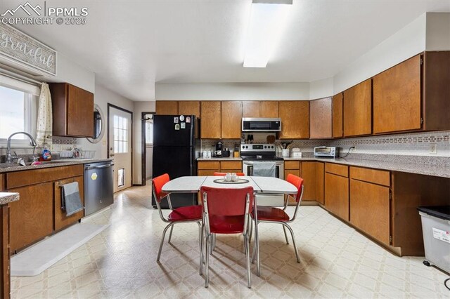 790 2nd Ave, Deer Trail, CO 80105 - kitchen featuring appliances with stainless steel finishes, a sink, light flooring, and brown cabinets