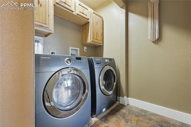 20420 Amanda Ct, Colorado Springs, CO 80908 - laundry area featuring washing machine and dryer, baseboards, cabinet space, dark stone finish flooring, and a textured wall