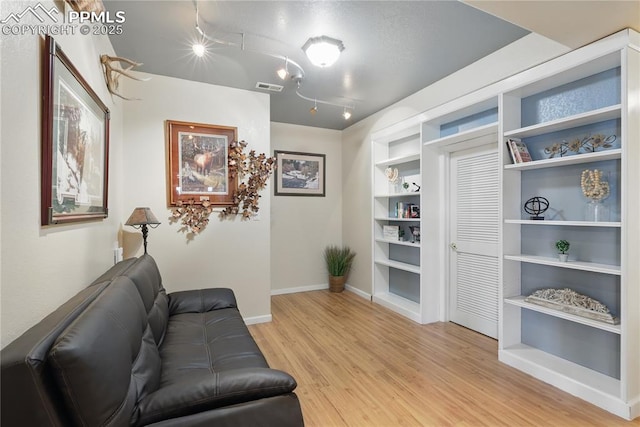 20420 Amanda Ct, Colorado Springs, CO 80908 - living area featuring rail lighting, wood finished floors, baseboards, and built in features