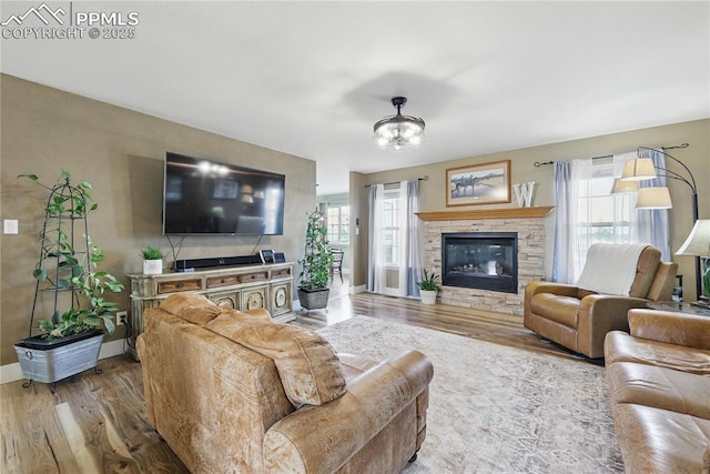 20420 Amanda Ct, Colorado Springs, CO 80908 - living room featuring wood finished floors, baseboards, a fireplace, and a chandelier
