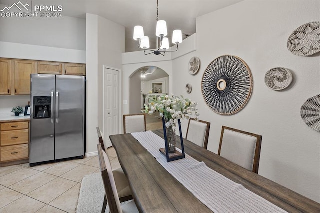 dining space featuring an inviting chandelier, arched walkways, and light tile patterned flooring