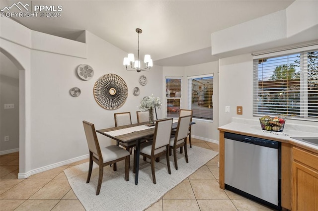 dining area featuring arched walkways, light tile patterned floors, baseboards, a notable chandelier, and lofted ceiling