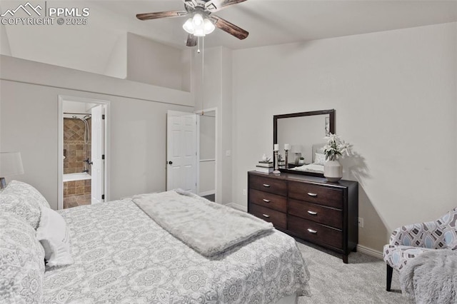 bedroom with ceiling fan, light colored carpet, vaulted ceiling, baseboards, and connected bathroom