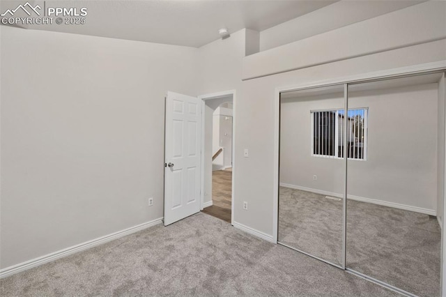 unfurnished bedroom featuring carpet flooring, baseboards, and a closet