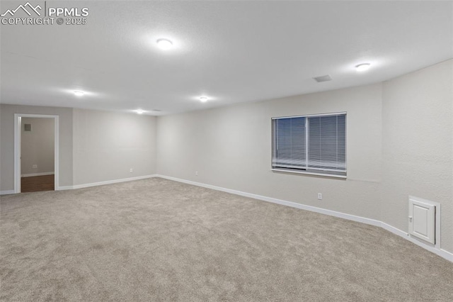 carpeted spare room featuring baseboards