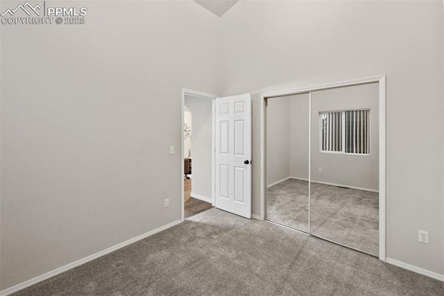 unfurnished bedroom featuring carpet flooring, baseboards, and a closet