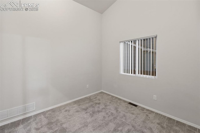 carpeted empty room featuring baseboards, visible vents, and vaulted ceiling
