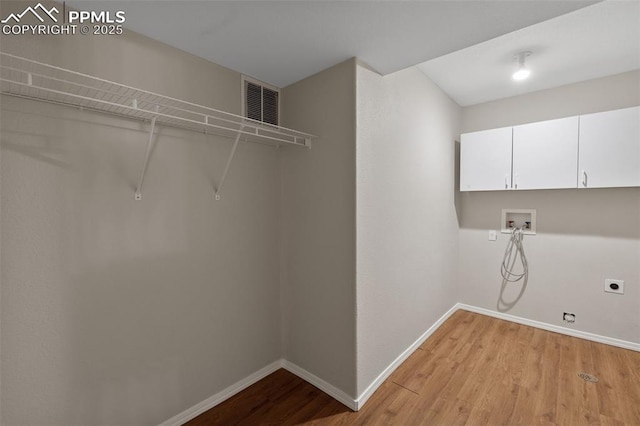 clothes washing area featuring cabinet space, washer hookup, light wood-style floors, baseboards, and visible vents