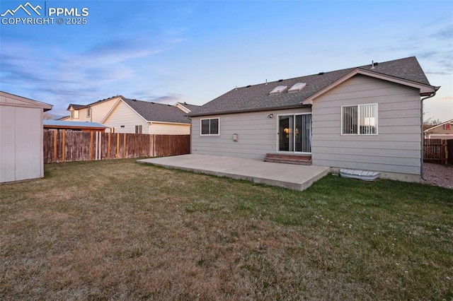 rear view of property with a fenced backyard, a lawn, and a patio area