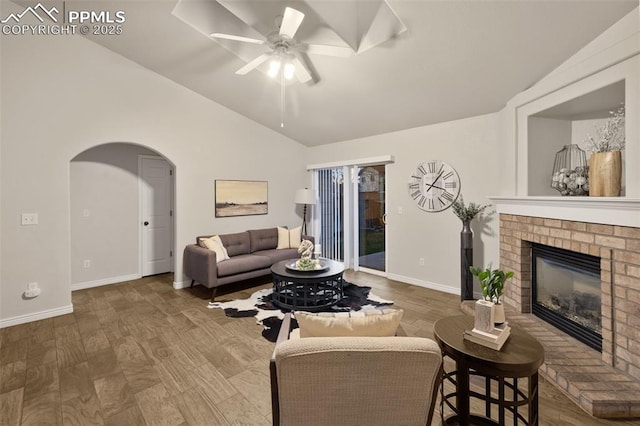 living room featuring a ceiling fan, arched walkways, baseboards, and lofted ceiling