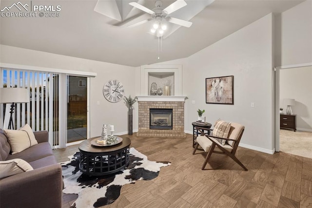 living room with a brick fireplace, a ceiling fan, wood finished floors, and lofted ceiling
