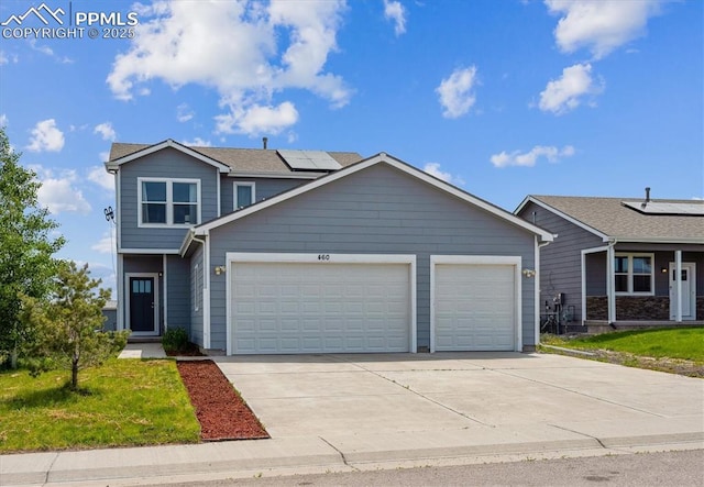 460 S 3rd Ave, Deer Trail, CO 80105 - view of front of house featuring an attached garage, solar panels, driveway, and a front yard