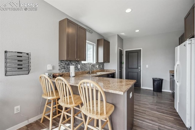 460 S 3rd Ave, Deer Trail, CO 80105 - kitchen featuring freestanding refrigerator, dark wood-type flooring, a peninsula, a sink, and recessed lighting
