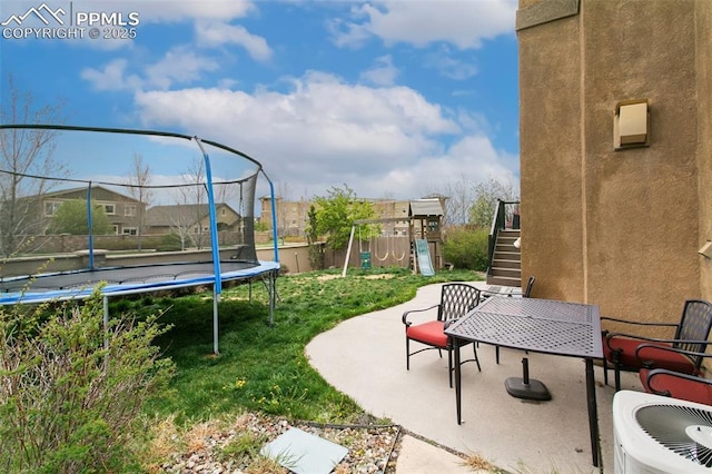 5019 Petrified Forest Trl, Colorado Springs, CO 80924 - view of yard with a trampoline, a patio area, outdoor dining space, a playground, and stairs