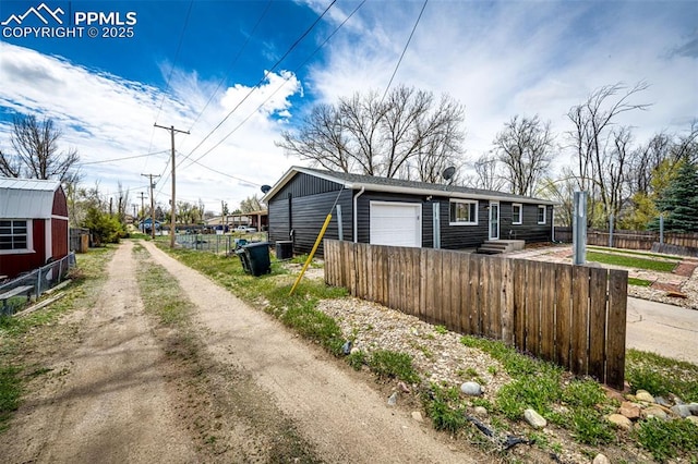1085 6th St, Limon, CO 80828 - exterior space with a garage, dirt driveway, and fence