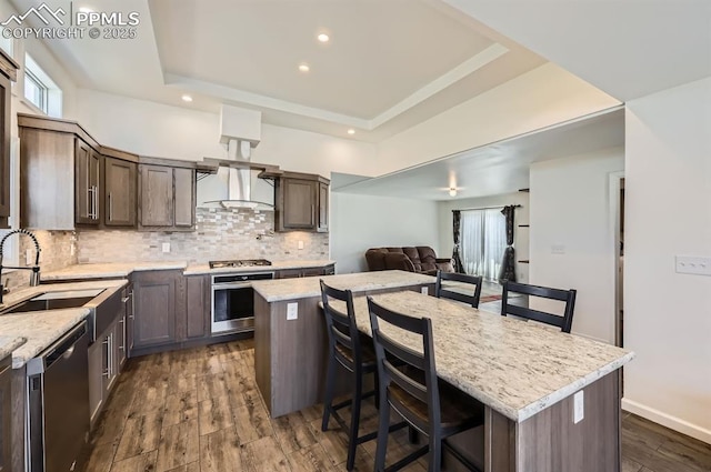 4157 Gray Fox Hts, Colorado Springs, CO 80922 - kitchen with a sink, a raised ceiling, a breakfast bar area, stainless steel appliances, and decorative backsplash