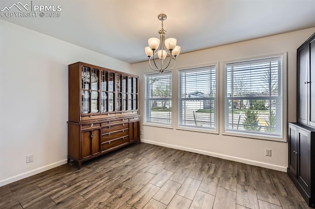 4157 Gray Fox Hts, Colorado Springs, CO 80922 - unfurnished dining area with baseboards, an inviting chandelier, and dark wood-type flooring