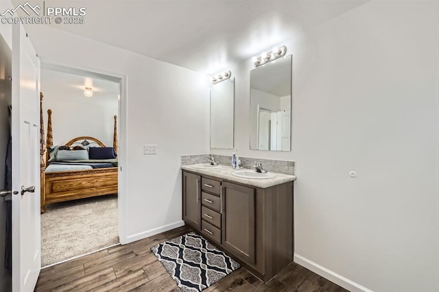 4157 Gray Fox Hts, Colorado Springs, CO 80922 - bathroom with baseboards, a sink, connected bathroom, and wood finished floors