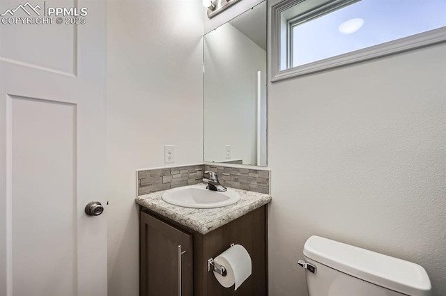 4157 Gray Fox Hts, Colorado Springs, CO 80922 - half bathroom featuring vanity, decorative backsplash, and toilet
