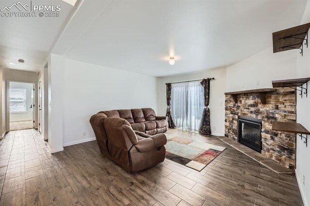 4157 Gray Fox Hts, Colorado Springs, CO 80922 - living area featuring baseboards, a stone fireplace, and wood finished floors